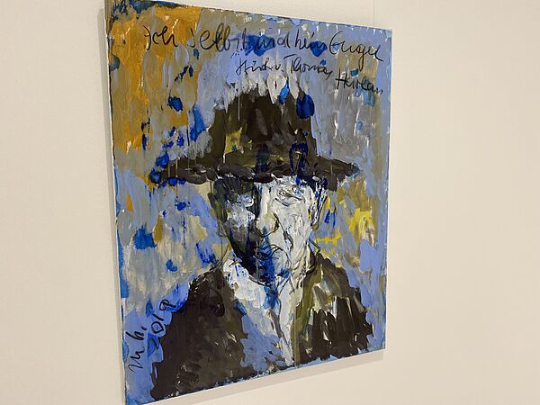 Ein quadratisches Bild an einer Wand. 