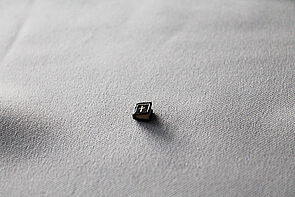 Ein klitzekleines Buch. Sein dunkler Einband ist auf der Titelseite silbernen umrandet. In der Mitte befindet sich ein silbernes Kirchenkreuz.