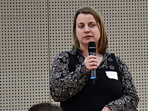 Manuela Heberer hält ein Mikrofon in der Hand.