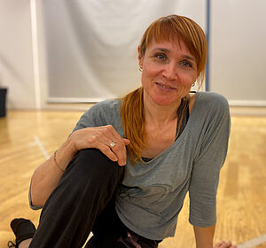 Yulia sitzt auf dem Boden des Tanzraums. 