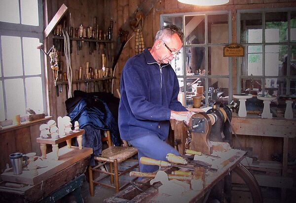 Ein Drechsler steht an seiner Werkbank.