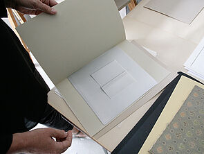 Julia Hansen blättert in Papiermappen.