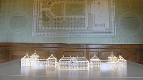 Auf einem Tisch steht ein durchsichtiges Modell von Schloss Bothmer. Es leuchtet.