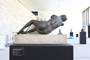 Eine Skulptur zeigt eine liegende Frau von hinten.