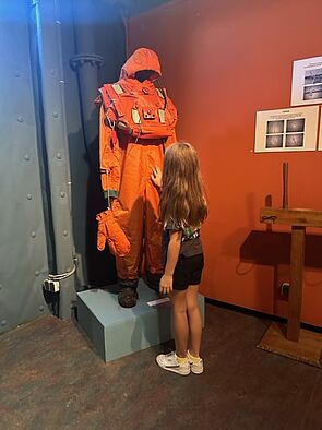 Ein Mädchen an einem orangen Ganzkörperanzug