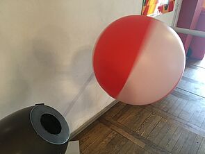 Über einer Art Kanonenrohr schwebt ein Wasserball.