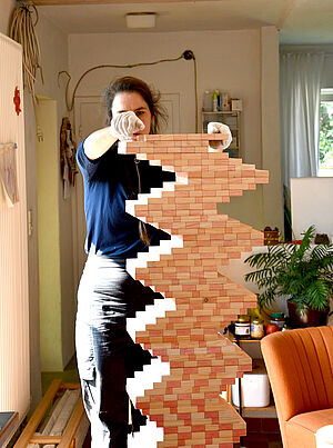 Marike Schreiber baut eine Holzskulptur auf.