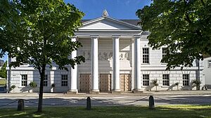 Ein weißes Gebäude mit Säulenportal.