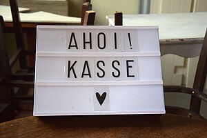 Im Foyer steht ein Schild mit der Aufschrift "Ahoi! Kasse".