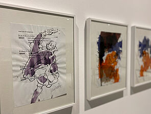 Drei Gemälde hängen nebeneinander.